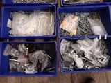 many different types of screws and nails in blue bins