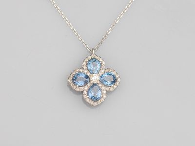 a blue topaz and diamond flower pendant on a chain