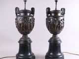 paire d'urnes antiques en bronze posées sur des socles en marbre noir