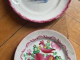 two plates that are sitting on a wooden floor