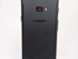 the back of a black samsung galaxy s3 phone on a white surface