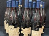 six bouteilles de vin sont alignées sur une table