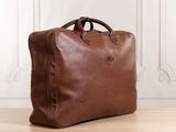 a brown leather briefcase sitting on top of a wooden floor