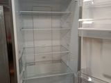 an empty refrigerator with its door open in a kitchen