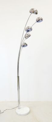 un lampadaire posé sur une table sur laquelle se trouve un ordinateur portable