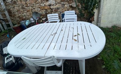 une table et des chaises blanches dans la cour