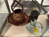 a glass display case with a teapot and a plate on it