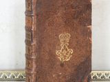 un vieux livre orné d'une couronne, posé sur une table