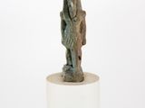 statue d'un homme portant un sac à dos, debout sur un socle blanc