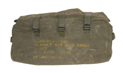 un vieux sac militaire sur lequel est inscrit un message, posé sur une surface blanche