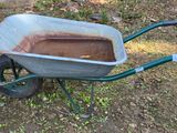 a wheelbarrow that is sitting in the grass