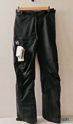 leather pants hanging on a hanger on a wall in a room