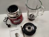 a blender sitting on a table next to a book