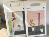 two boxes with plants on them sitting on a wooden table