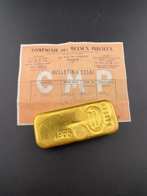 a piece of gold on the table next to a receipt
