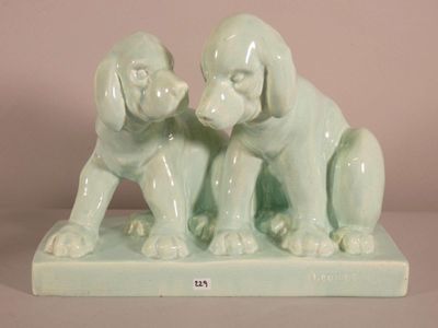 two figurines of dogs sitting on top of a table