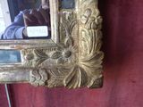 a picture of a gold mirror hanging on a wall