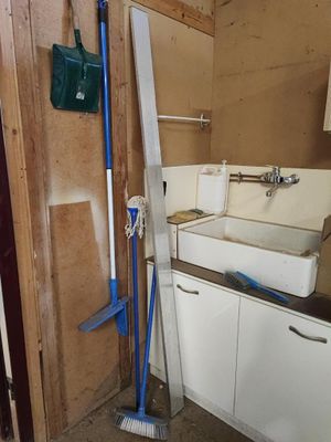 une photo d'une salle de bains avec un lavabo et un balai