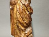 carved wooden statue of a man with a hat and a robe