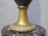 un vase vert posé sur un socle en marbre
