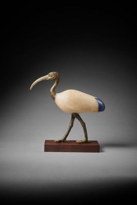 wooden sculpture of a bird with a long beak on a wooden base