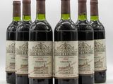six bouteilles de vin sont alignées sur une surface blanche