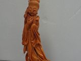 carved figurine of a woman holding a bird on a wooden base