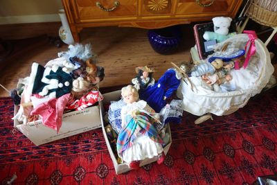 de nombreuses poupées qui sont posées dans une boîte posée par terre