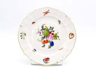 une assiette blanche décorée d'un oiseau et de fleurs
