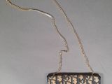 a black and gold purse with a chain hanging from it