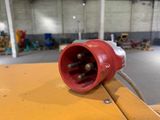 a close up of a red electrical plug on a yellow table
