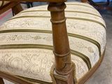 a chair that has a striped seat and a wooden frame