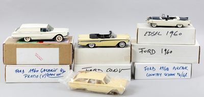 quatre petites voitures sont posées sur des cartons