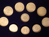 nine coins arranged in a circle on a black surface