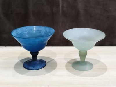deux verres en verre bleu et vert posés sur une table