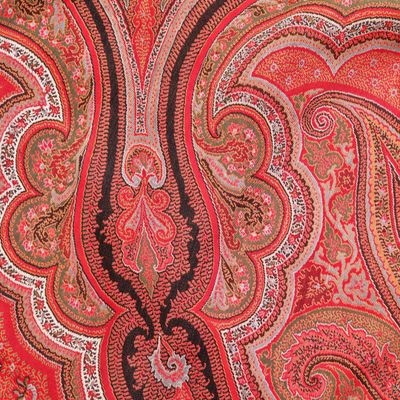 une photo montrant un gros plan d'un tissu à motifs paisley rouges et marron