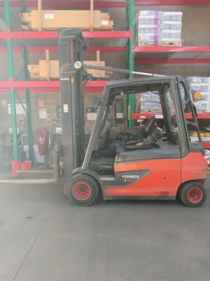 a fork lift truck in a warehouse with boxes on the shelves