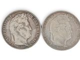 a close up of two silver coins on a white surface