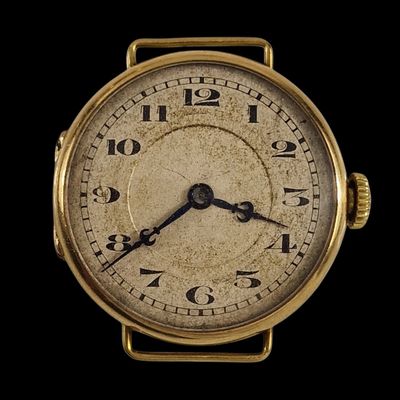 un gros plan d'une montre-bracelet en or sur fond noir
