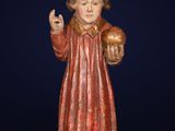 a statue of a man holding a ball on top of a marble base