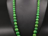 un collier de perles vertes sur un mannequin noir