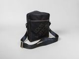 a black cross body bag sitting on top of a white surface
