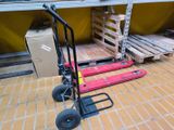 a hand truck that is sitting on the floor next to pallets
