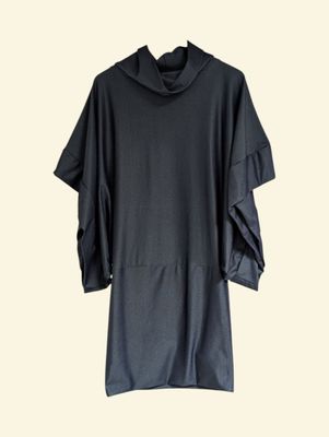 the black dress is hanging on a hanger on a white wall