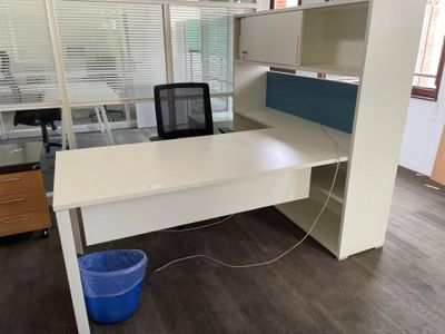 a white desk with a blue chair and a blue bucket in front of it