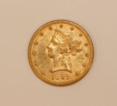 a close up of a gold coin with a woman ' s head on it