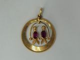 a close up of a gold plated pendant with two birds on it