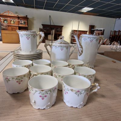 Plusieurs tasses et soucoupes sont disposées sur une table dans une pièce