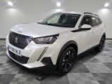 un 4x4 blanc garé sur un sol en damier dans un garage
