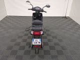 a motor scooter parked in a room with a checkered floor